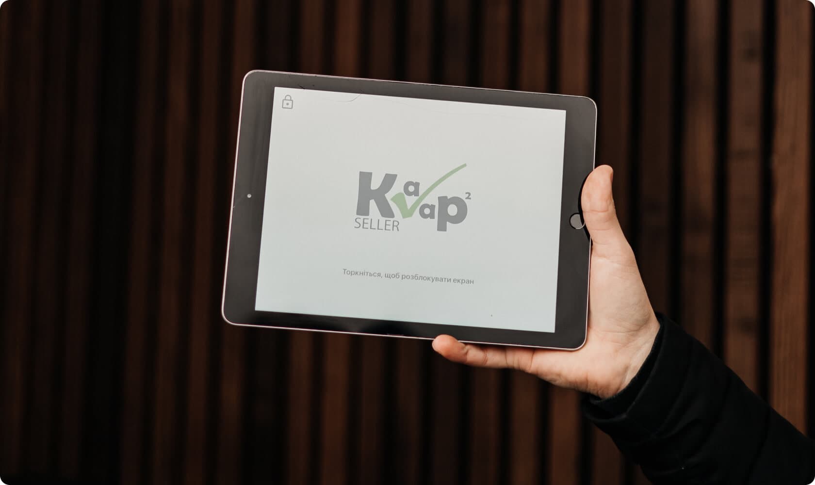 Планшет з заставкою додатку Kavapp Seller у руці